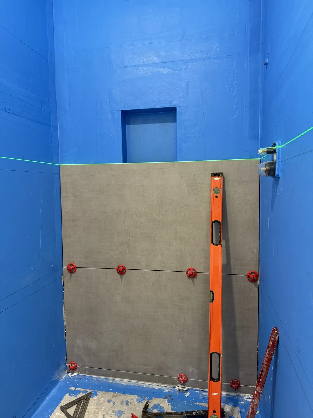 First course of wall tile set to a laser line.