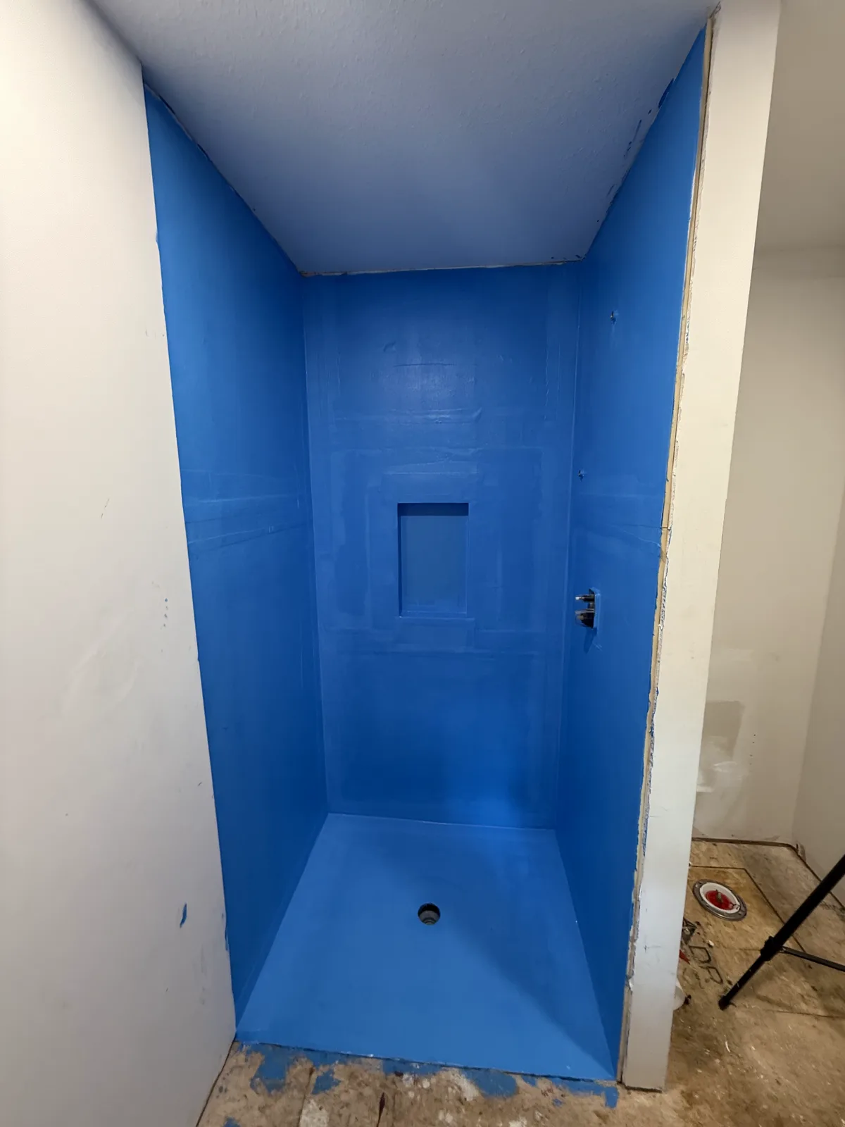 The shower pan, walls and niche fully waterproofed before any tile.
